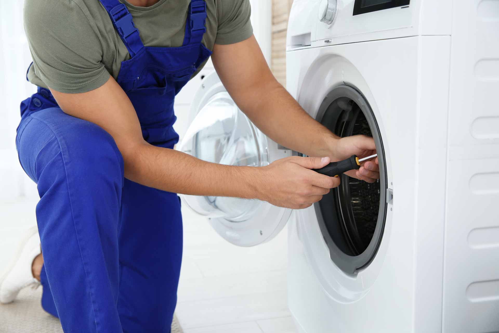 Appliance repair technician repairing a washer/dryer