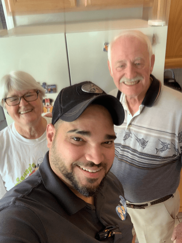 Technician from Elmo's Appliance Repair posing with satisfied customers