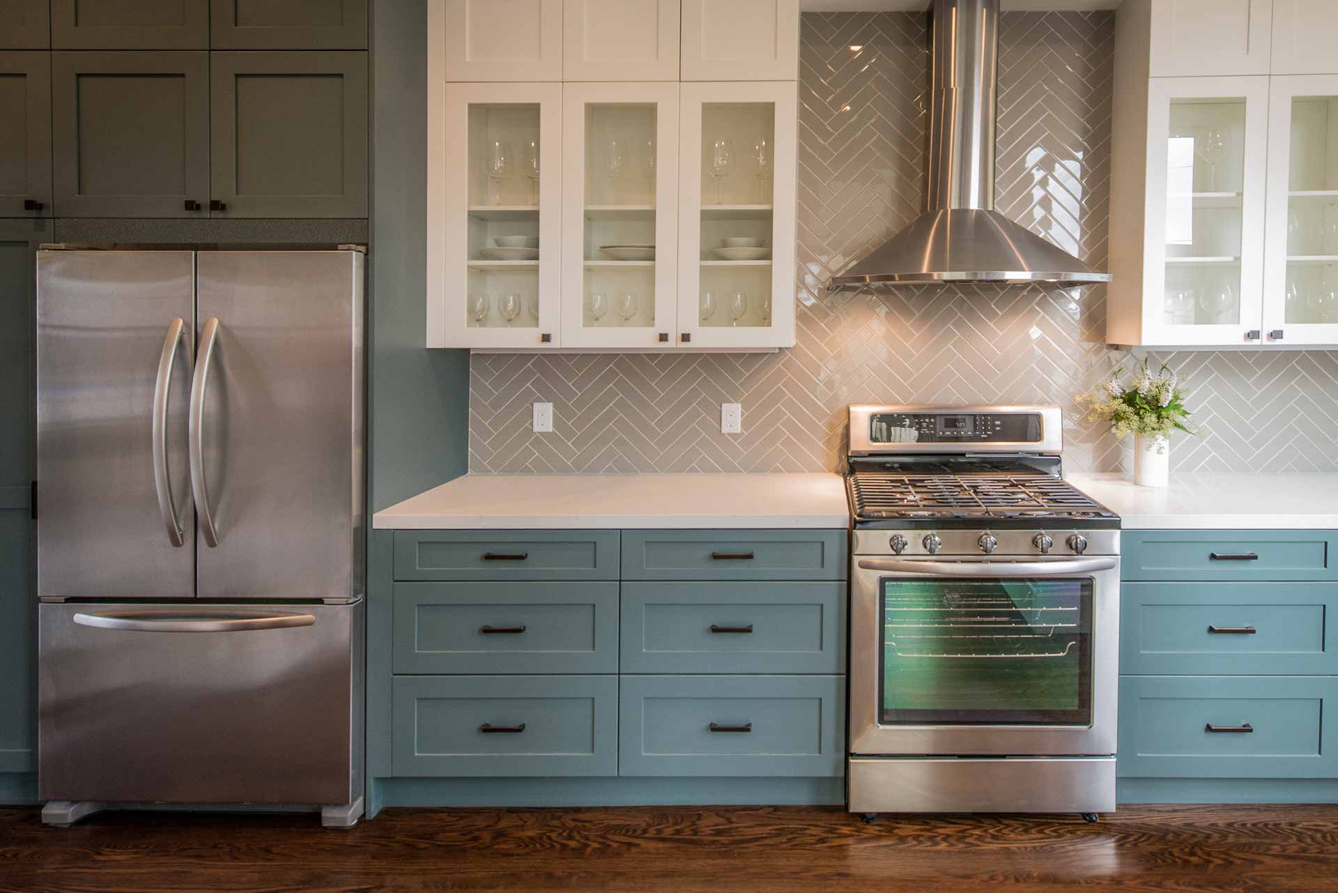 Kitchen with a gas oven, vent hood, and a refrigerator