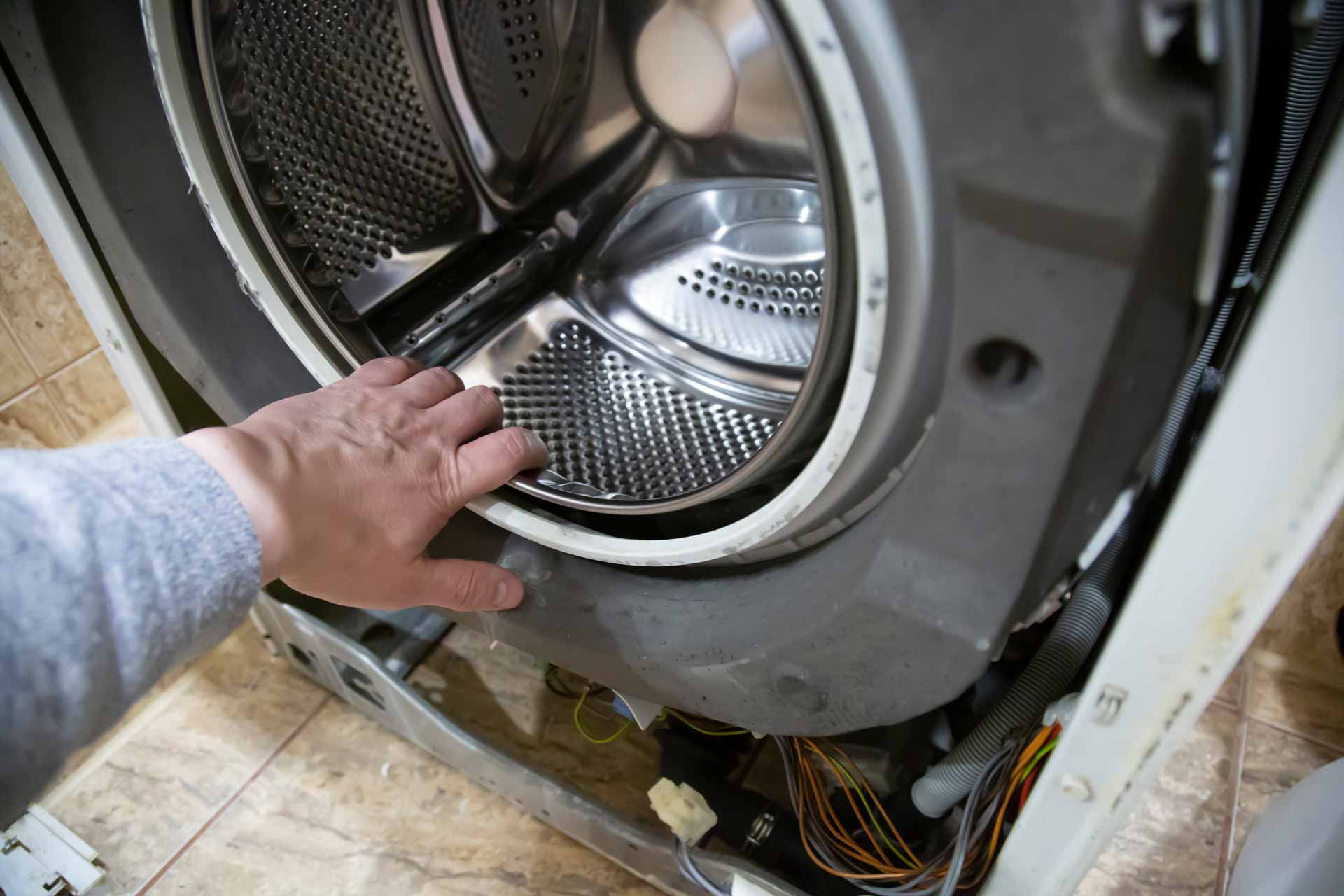 Hand reaching in to washer/dryer drum