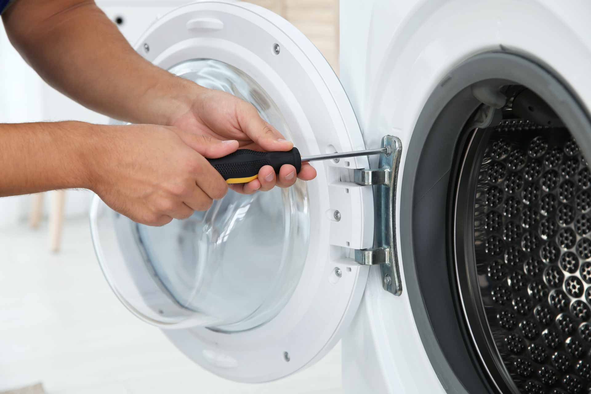 Technician removing the door from a washer/dryer